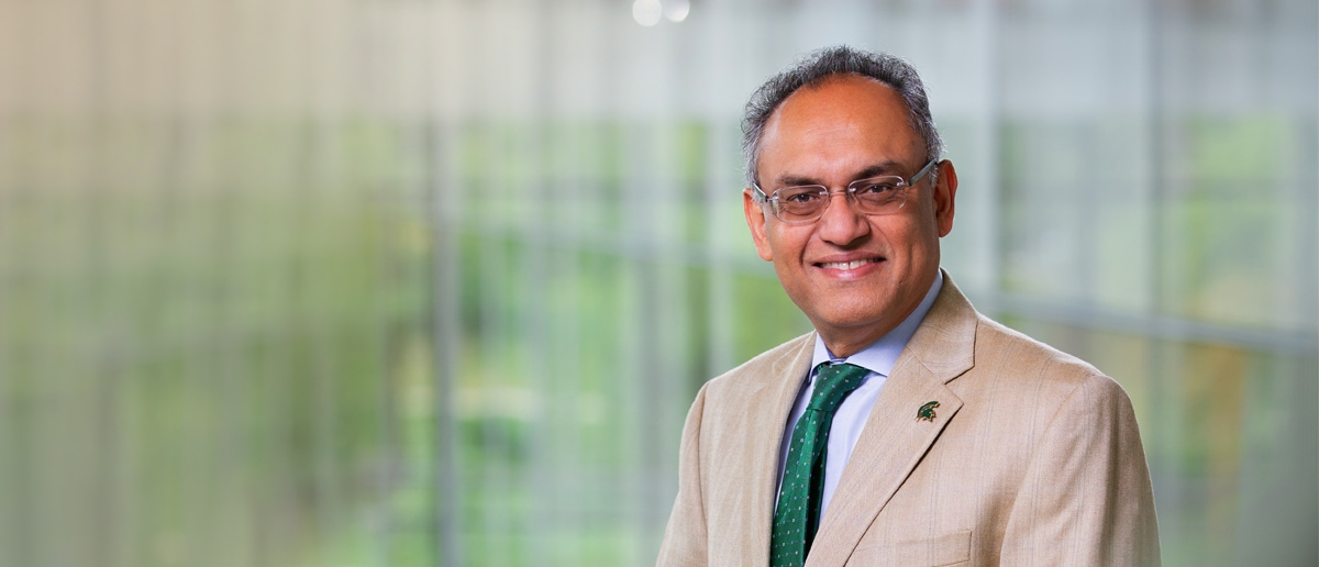 A professional headshot of Eli and Edythe L. Broad Dean Sanjay Gupta in the Minskoff Pavilion on MSU's campus.