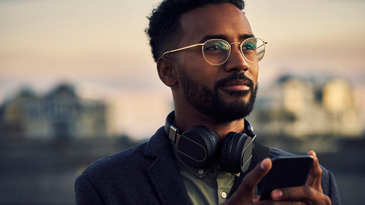 A young businessman stares into the distance at a city sunset