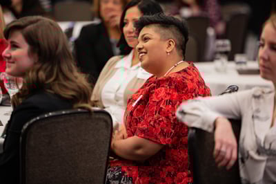 A woman smiles and engages with others at the Broad College's annual Advancing Women in Busine