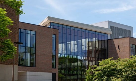 A glass wall of the Minskoff Pavilion on a bright, clear day