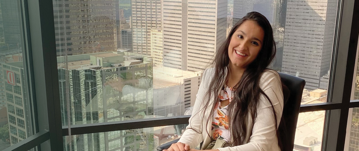 Simone Nagi in front of a window in a high-rise office building