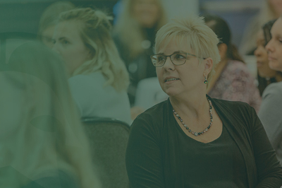 A woman in the audience pays attention to a speaker