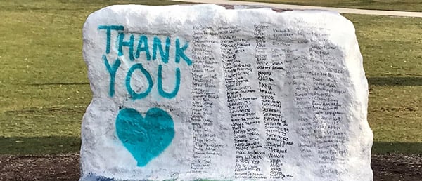 The Rock, painted white, with 'THANK YOU' and a heart painted on in teal, and next to it black lettering of all the survivors who testified at Larry Nassar's Ingham County sentencing.