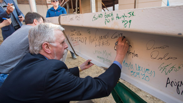 Carl Borchgrevink signs a beam of the Business Pavilion