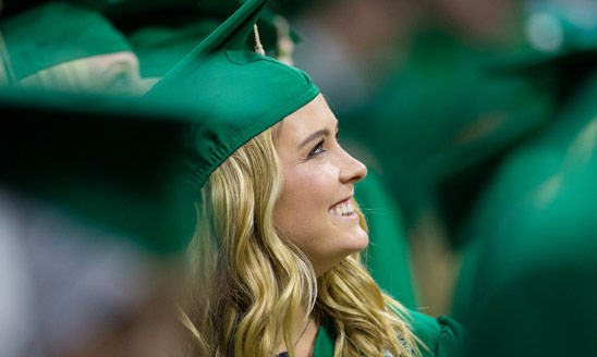 A smiling graduate in cap and gown