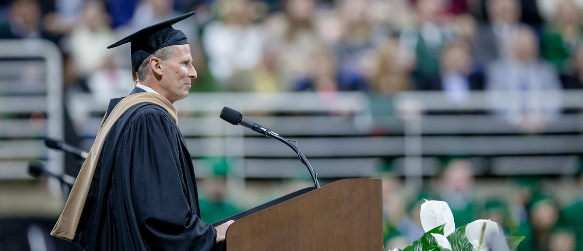 Todd Penegor speaking at a past MSU commencement ceremony in-person.
