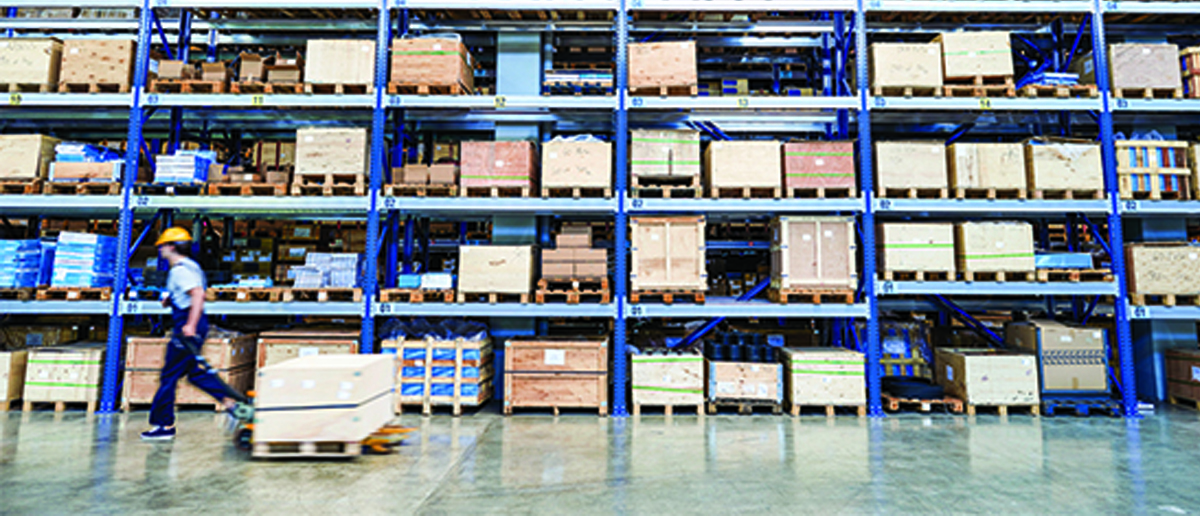 A retail warehouse with a worker moving boxes.
