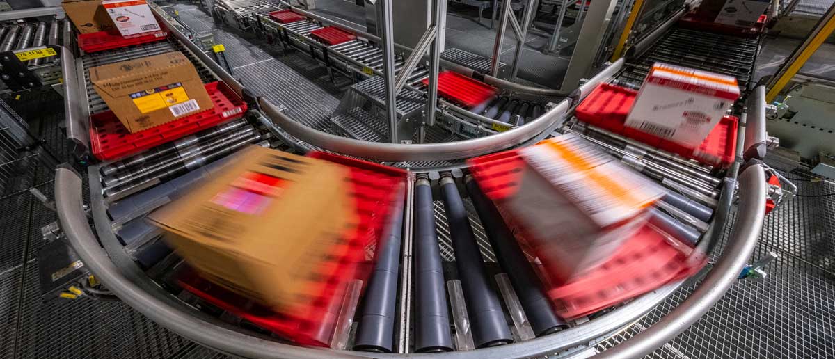 Blurry packages speed around a U-shaped conveyor belt