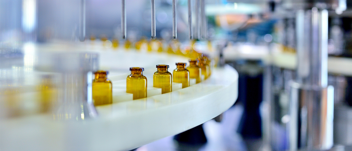 Close up image of medical bottles being filled in a production facility.