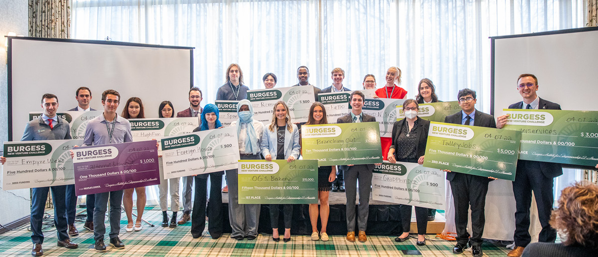 All 21 participants in the Burgess New Venture Challenge, holding oversized checks