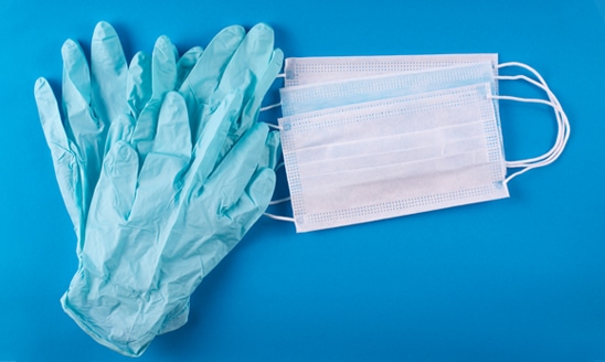 Medical gloves and masks on a blue background.